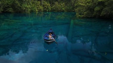 Endonezya, Sulawesi 'de kristal şeffaf gölde yüzen bir kadın. Yüksek kalite 4k görüntü