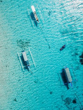 Tekneler, Bali adasındaki şeffaf mavi okyanusta demirlediler. Hava görünümü.