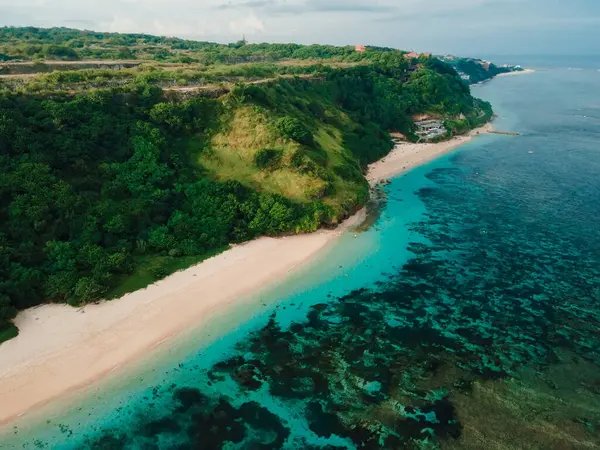 Bali adasında yeşil kayalıkları ve okyanusu olan manzaralı bir sahil. Tropik Pandawa plajının havadan görünüşü