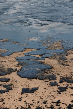Bir tanker kazasından sonra deniz kıyısında yakıt sızıntısı. Petrolle kirlenmiş plaj