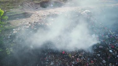 Bali 'de zehirli dumanla yanan yasadışı çöplük. Çöp sahalarındaki plastik çöplerle kirlilik, hava manzarası. Yüksek kalite 4k görüntü