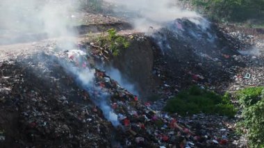 Bukit, Bali 'de yasadışı çöplük yakmak. Hava manzaralı. Çöp sahasındaki plastik çöplerle kirlilik. Yüksek kalite 4k görüntü