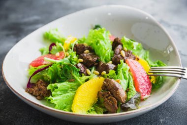 Et, narenciye ve salata yapraklı lezzetli salata, sağlıklı diyet yemekleri.