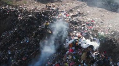 Bali 'de zehirli dumanla yanan yasadışı çöplük. Çöp sahalarındaki plastik çöplerle kirlilik, hava manzarası. Yüksek kalite 4k görüntü