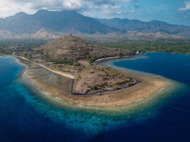 Pemuteran, Bali 'de mavi okyanuslu ve dağlı manzara. Hava görüntüsü