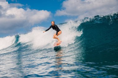 Sörf tahtasında güzel sörfçü kız. Sörf sırasında okyanusta bir kadın. Sörfçü ve varil dalga