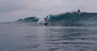 13 Mart 2025. Bali, Endonezya. Kadın sörfçü okyanus dalgasında sörf tahtasına biniyor. Bali 'de sörf