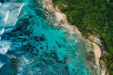 Turkuaz berrak okyanusu ve Bali 'de yeşil uçurumları olan güzel bir sahil şeridi. Tropikal adanın havadan görünüşü
