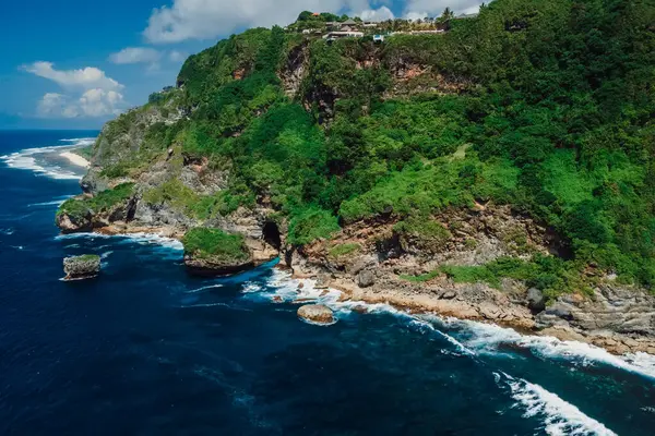 Kayalıklı manzara, kıyı şeridinde uçurum ve mavi okyanus. Hava görünümü