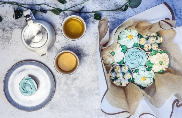 Cupcake decorated with white various colors flower icing isolated on white background. Shoot from top. Floral bouquet. Wedding cupcakes. Mothers Day,Birthday, Valentine Holiday Romantic