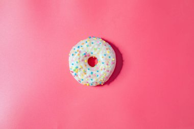 Donuts with icing on pastel pink background. Sweet donuts. top view assorted with various chocolate glazed and sprinkles, sugar sweets concept candy