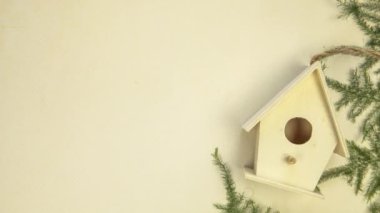 Wooden birdhouse moving left to right on yellow background with fresh green leafs, copy space, 4k looping. copy space spring concept beauty