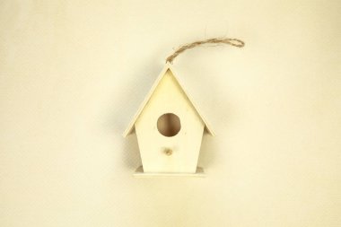 Beautiful bird house on beige background, top view. Space for text Spring concept wooden handmade birdhouse green leafs