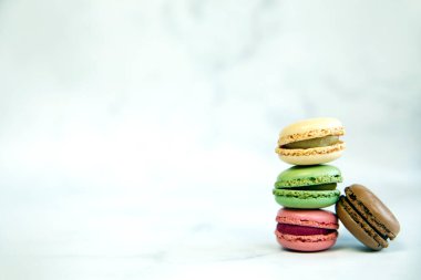 French Colorful Macarons Colorful Pastel Macarons on White Background pastel Pink and Brown Macaron with Fresh Blueberry, sweet cake stack copy space snack