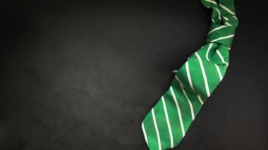 Elegant green business tie on dark background Elegant man clothes concept. wardobe and accessories for official party or evening meeting. Placed on black backgound. tie. Top view. Flat lay with copy