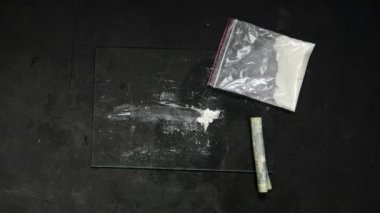 Kokain bağımlısı kokain ya da rulo dolarla ezilmiş haplar. Uyuşturucu Bağımlısı. Yasadışı uyuşturucu kaçakçılığı, yasadışı iş. Alışkanlık, uyuşturucu bağımlılığı. 4 bin. Yüksek kaliteli 4k görüntü üst görünümü
