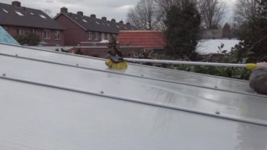 Alüminyumdan yapılmış teras pergola kapağını yıkıyorum. Kirli yosunları fırça sabunu ve suyla temizleyerek bahçeyi teras temizliğinden, işçilerden, konseptten temizler.