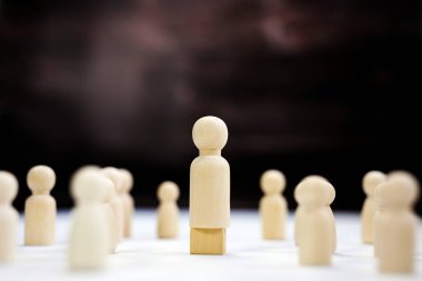 Takım lideri maketi, uzayı kopyala. Liderlik, kazanmak, patron. Kazanan ve yenilen. Küp üzerindeki ahşap figür, metin alanı kavramını oluşturan bir iş ekibi grubuna liderlik ediyor