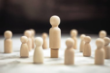 Takım lideri maketi, uzayı kopyala. Liderlik, kazanmak, patron. Kazanan ve yenilen. Küp üzerindeki ahşap figür, metin alanı kavramını oluşturan bir iş ekibi grubuna liderlik ediyor