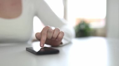 Mobil ekran akıllı telefonunda uygulama kullanan genç bir kadın. Teknoloji kullanımı, internetten alışveriş, mobil uygulamalar, mesajlaşma, bağımlılık, kaydırma, kaydırma. Çevrimiçi randevu uygulaması kullanılıyor