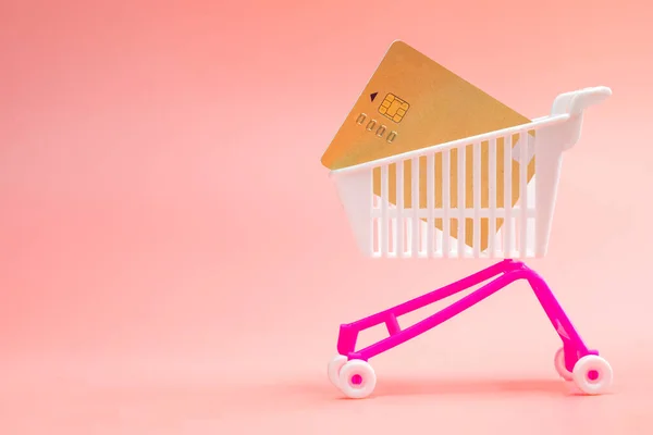 분홍색 배경에 카드가 카트를 구입하 온라인 쇼핑에 슈퍼마켓 신용카드 메시지를 — 스톡 사진