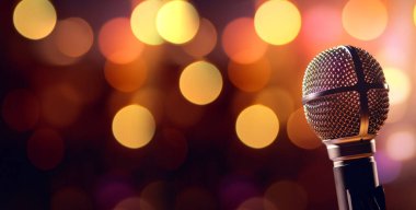 Stüdyo mikrofonu neon ışıklarda. Bokeh arkaplanındaki ses kayıt ekipmanları. Podcast, müzik konsepti mikrofon kopyalama alanı