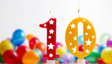 Beyaz arka planda yanan doğum günü mumu, renkli 10 numara, 10. yaş günü beyaz arka planda renkli balonlar, parti mumları, doğum günü kutlamaları