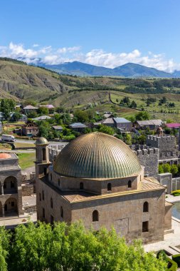 Akhmediye Cami Binası 'nda Akhaltsikhe Kalesi avlusunda altın kubbe, Akhaltsikhe Köyü' nde ortaçağ kalesi ve arka planda Kafkasya Dağları bulunur..