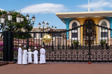 Muscat, Umman, 29.01.2020. Eski Muscat, Umman 'daki renkli Al-Alam Sarayı' nın önünde duran geleneksel kanduralı küçük Müslüman çocuklar.