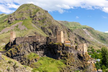 Khertvisi Fortress, Georgia, summer landscape with stone medieval castle with watchtowers on the rocky hill and green Lesser Caucasus mountains in the background, Samtskhe - Javakheti region.