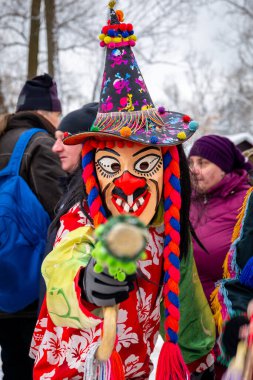 Milowka, Poland, 21.01.2023. Gody Zywieckie - traditional winter parade of 'Dziady', folk custom in Zywiec region, man dressed in colorful costume of a clown, performing on a street.