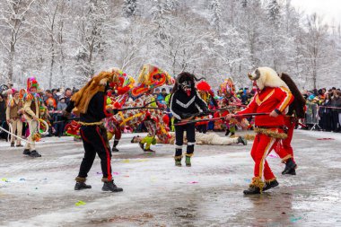 Milowka, Poland, 21.01.2023. Gody Zywieckie - traditional winter parade of 'Dziady', folk custom in Zywiec region, men dressed in traditional costumes of devils dancing on a street.