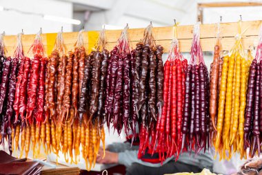 Colorfull churchkhela, traditional Georgian candle-shaped candy made of grape must, nuts, and flour, hanging on a market stall in Kutaisi Central Market (Green Bazaar,  Mtsvane Bazari).