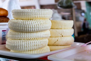 Georgian Sulguni cheese round discs stack on a market stall in Kutaisi Central Market (Green Bazaar,  Mtsvane Bazari).