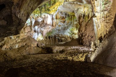 Prometheus Cave Natural Monument - largest cave in Georgia with petrification waterfalls, hanging stone curtains, stalactites and stalagmites, colorful illuminated rock formations.