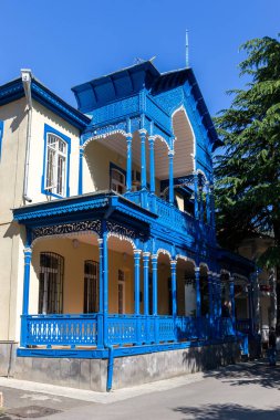 Geleneksel Borjomi bina cephesi mavi oyulmuş ahşap balkon ve terası doğu tarzı, Georgia.