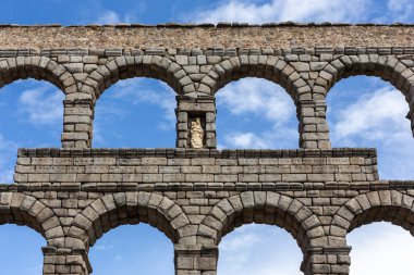 Segovia 'nın su kemeri, İspanya, antik Roma taş yapısı, Segovia' nın sembolü, Bakire Meryem 'e uygun, mavi gökyüzüne karşı simetrik görüş.