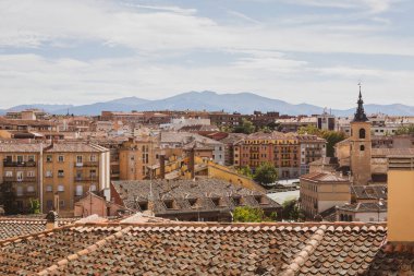 Segovia, İspanya, 03.10.21, Calle de Juan Bravo, Segovia 'da dar bir ortaçağ sokağı. Geleneksel bina cepheleri ve balkonları ve Iglesia de San Martin kilisesi arka planda yürüyen insanlar..