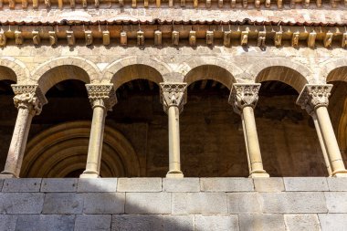 Segovia, İspanya, 03.10.21, Calle de Juan Bravo, Segovia 'da dar bir ortaçağ sokağı. Geleneksel bina cepheleri ve balkonları ve Iglesia de San Martin kilisesi arka planda yürüyen insanlar..