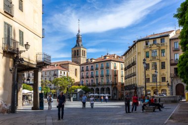 Segovia, İspanya, 03.10.21. Plaza Belediye Başkanı şehir merkezi, Segovia 'da şehir meydanı, Kafeler, restoranlar ve Iglesia de San Marté Kilisesi' nin çan kulesi arka planda yürüyen insanlar.