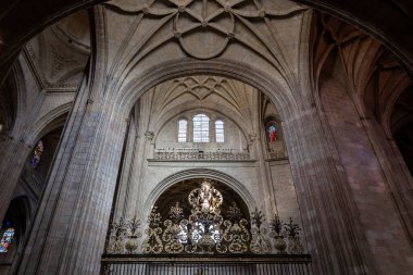 Segovia, İspanya, 03.10.21. Segovia Katedrali 'nin içindeki simetrik dekoratif Gotik kasalar çiçek oymaları, vitray pencereler, sütunlar ve dekoratif kapılar, karanlık uğursuz iklim..