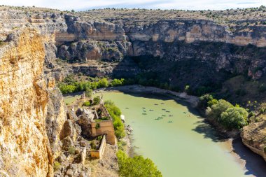 Hoces del Rio Duraton Doğa Koruma Alanı (Parque Natural de las Hoces del Rio Duraton) dikey kireçtaşı uçurumları, mavi su ve yüzen renkli kanoları ile.