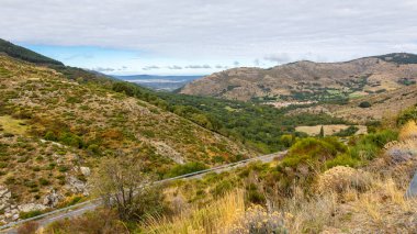 Arka planda Navacepeda de Tormes köyü, AV-931 plataforma de Gredos parkına dönen asfalt yolu ile Sierra de Gredos dağı manzarası.