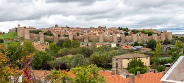 Avila şehri yüksek çözünürlüklü panorama etrafında siperleri, Gotik mimarisi ve yeşil bitki örtüsü olan ünlü ortaçağ şehir duvarları.