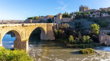 San Martin Köprüsü, Tagus Nehri üzerinde ortaçağ köprüsü ve arka planda San Juan de los Reyes Manastırı, Toledo, İspanya.