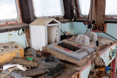 Terk edilmiş ve yıkılmış kargo gemisi köprüsü içeriden görülüyor gaz kolları, iletişim cihazları ve ekipmanlarla, El Hamriyah sahilinde karaya vurmuş, Umm Al Quwain, Birleşik Arap Emirlikleri.