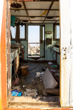 Umm Al Quwain, UAE, 11.11.20. View through a demolished wheelhouse of a cargo ship wreck after marine disaster, inside view of the bridge with communication devices and equipment, Al Hamriyah beach. clipart