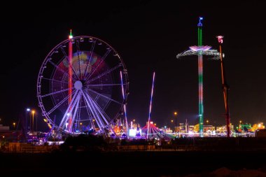 Dubai, BAE, 11.11.20. Küresel Köy eğlence parkı gece manzarası aydınlatılmış dönme dolap ve park binaları.