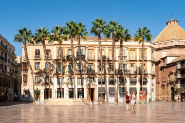 MALAGA, İspanya, 01.09.2019. Anayasa Meydanı (Plaza de la Constitucion), İspanyol mimarisi ve palmiye ağaçları ile ikonik halk meydanı, selfie çeken turistler, yaz güneşli günü.