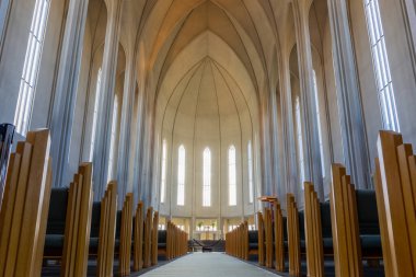 Reykjavik, İzlanda, 14.05.22. Hallgrimskirkja modernist kilise Gotik ana körfez ahşap banklar, maymun ve sunak, yüksek kemerli pencereler ve beton duvarlar, insan yok.
